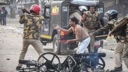 Policeman hits a civilian during a protest against the Citizenship (Amendment) Act