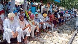 Farmers block railway track as they stage a protest against Farms bills, in Bathinda on Saturday.