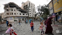 Residents move away for safer spots amid destroyed buildings and debris around the Palestinian Telecommunications Company, which was targeted, after Israeli airstrikes in Gaza Strip on October 10, 2023. Photo: Anadolu Agency