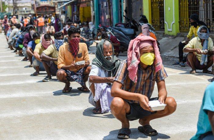 Workers waiting for food, Photo by PTI