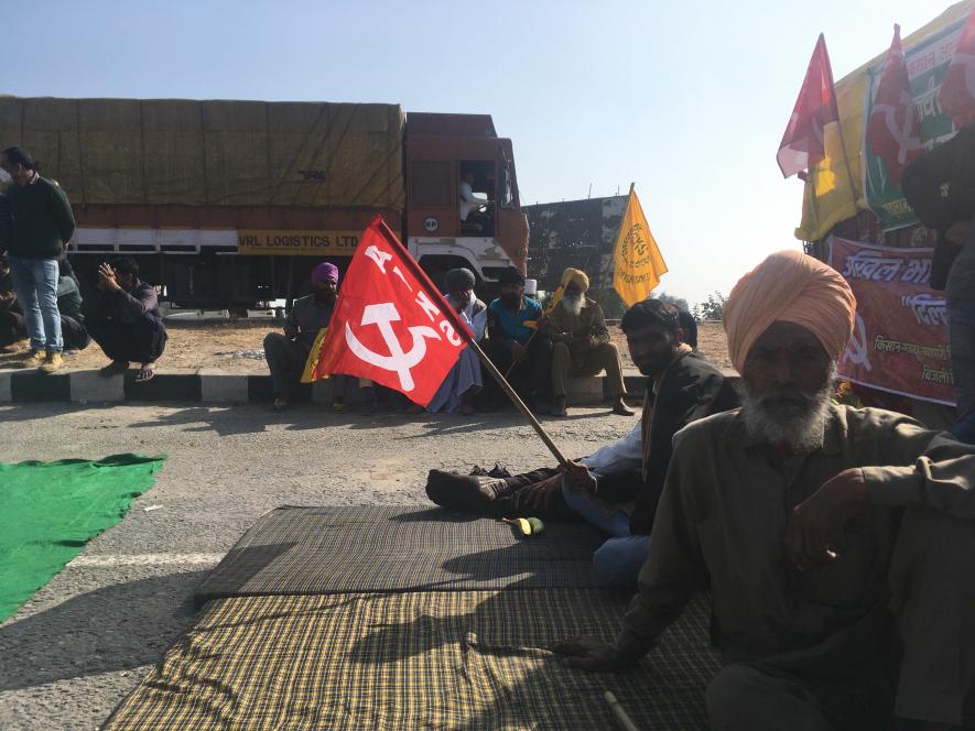 A farmer from Rajasthan posing for the picture. Behind him is the union flag of AIKS. Image clicked by Ronak Chhabra