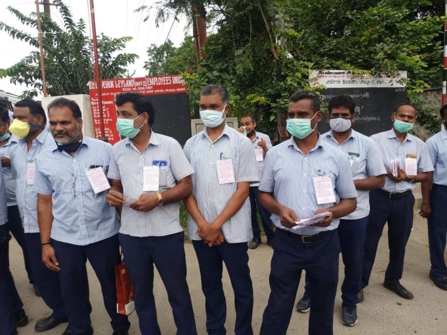 Workers wearing badges demanding early settlement of wage talks