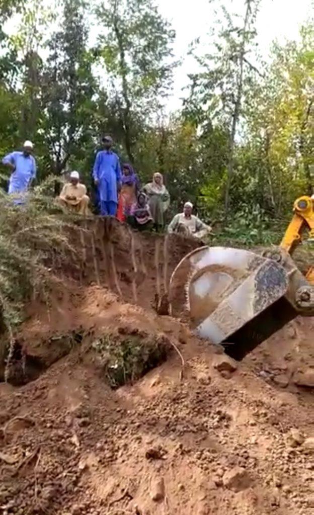 JCB machine excavating soil from Budoos’ land.