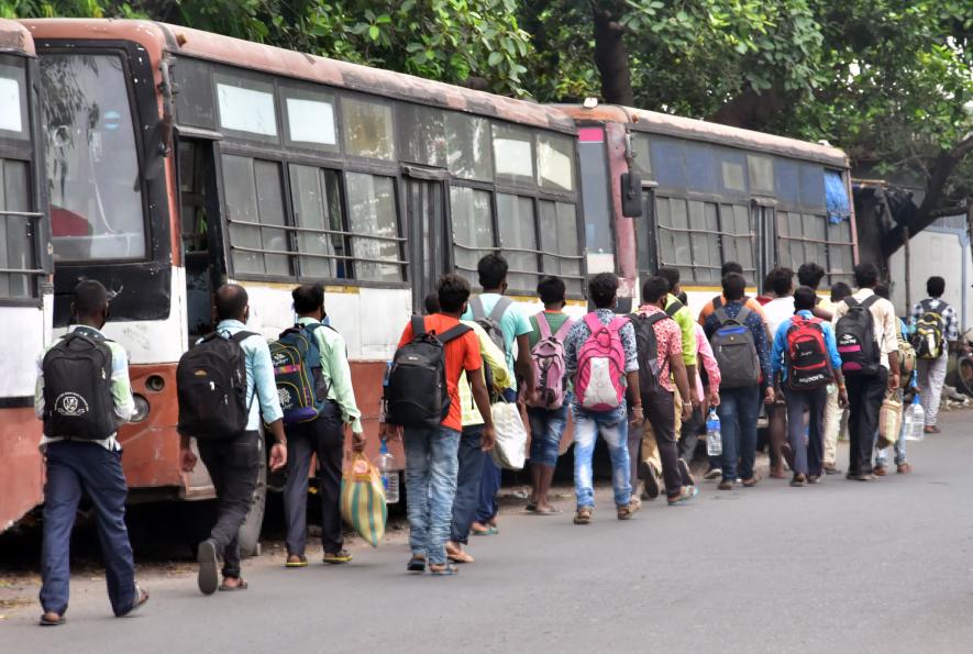 Migrants labor go by foot to their home after arriving from the special train due to unavailability of transport