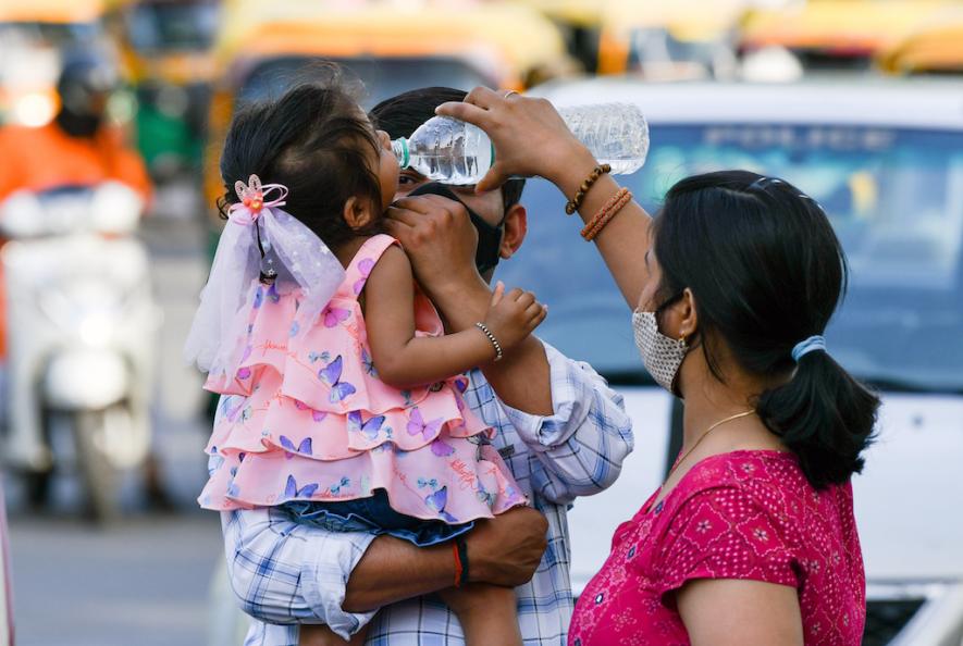 Apr 03 (ANI): A woman gives water to her child in respite from the heatwave on a hot summer day, in New Delhi on Sunday. 