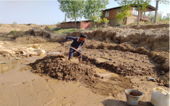 A labourer prepares the clay for manufacturing kachaa bricks at a brick kiln in Chandpora, Budgam district.