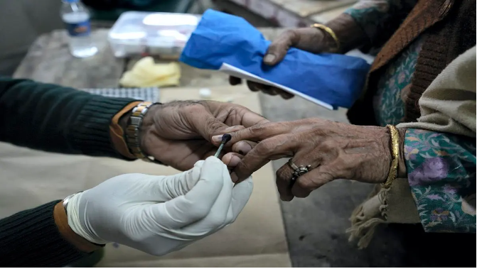 A voter gets her finger marked with indelible ink before casting her vote for the MCD polls, at a polling station in Majnu-ka-tilla area, in North Delhi