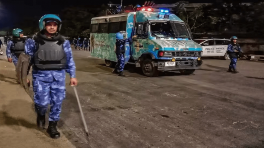 Rapid Action Force personnel conduct a flag march amid ongoing violence in Manipur, in Imphal, Sunday night, May 7, 2023.