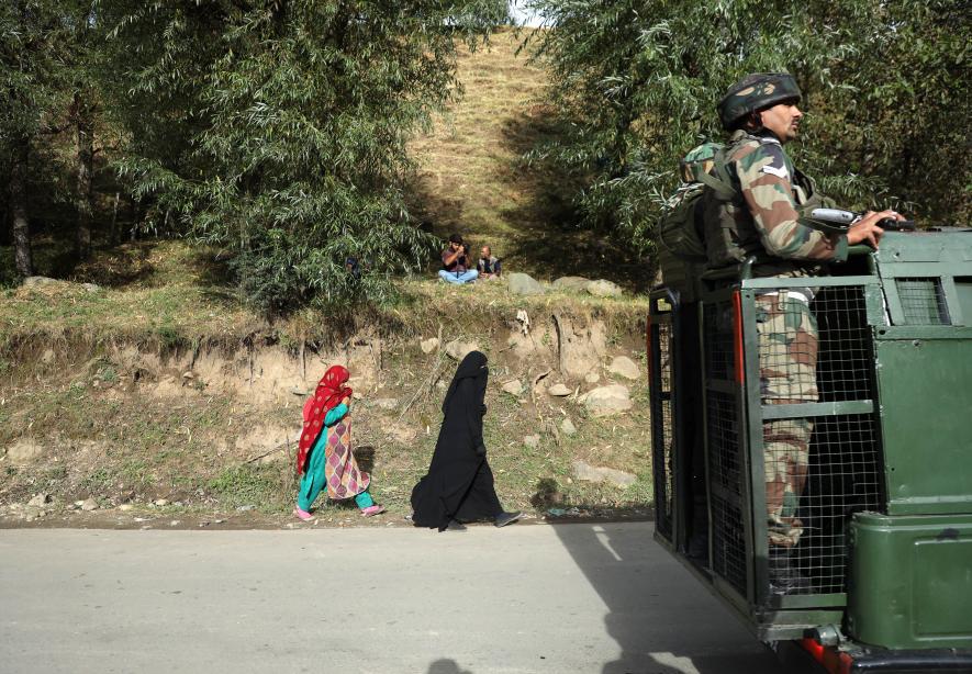 Locals walking toward the encounter site, while the Army stands guard.