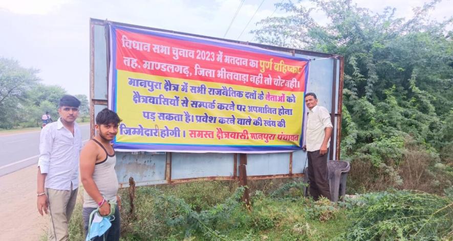 People of Manpura village holding banners to boycott elections in protest against its inclusion in Shahpura district (Photo - Farooq Luhar).