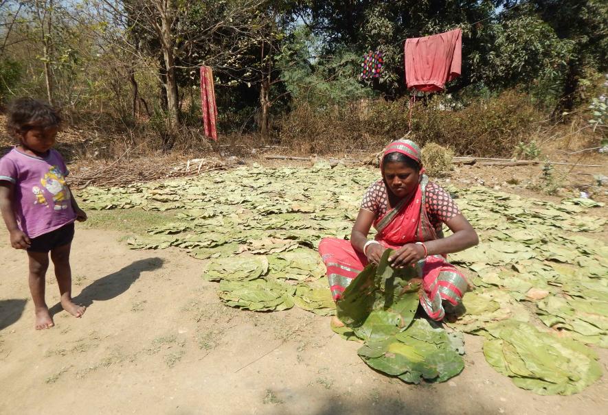 A woman sewing saal leaves