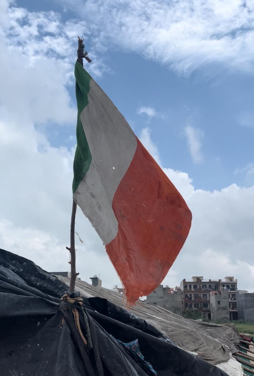 A slum dwelling displaying the tricolour without the Ashok Chakra